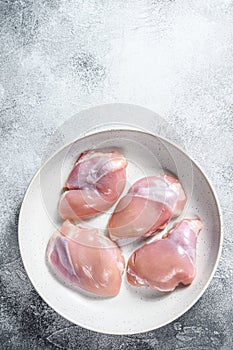 Raw chicken thigh fillet. Gray background. Top view. Space for text