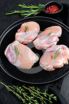 Raw chicken thigh fillet without skin. Farm poultry meat. Black background. Top view