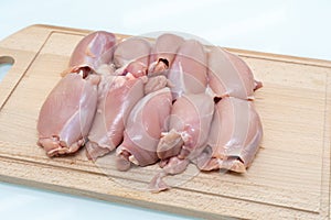 Raw chicken thigh flesh on a wooden cutting board