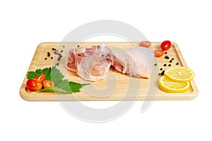 Raw chicken thigh and spices on wooden cutting board