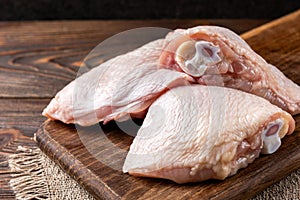 Raw chicken thigh on wooden.