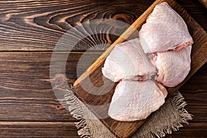 Raw chicken thigh on wooden. photo