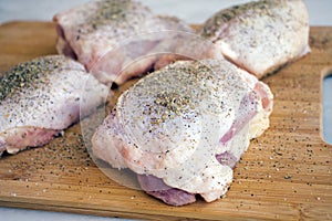 Raw Chicken Thighs Seasoned with Dried Herbs, Salt, and Pepper