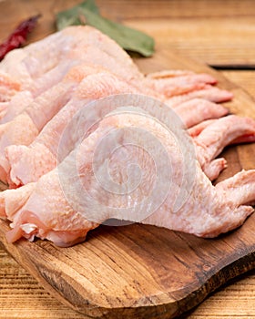 Raw chicken wings on a kitchen board with red hot peppers and spices. Raw chicken meat.Raw chicken wings on cutting board