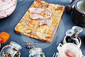 Raw chicken wings with spices on a wooden cutting board