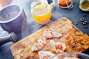 Raw chicken wings with spices on a wooden cutting board