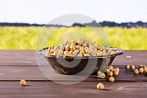 Raw chickpeas kabuli with field behind