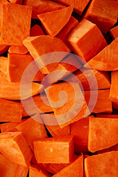 Raw Chopped Sweet Potatoes on a Cutting Board, top view. Flat lay, overhead, from above