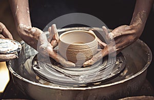 A raw clay pot in the hands of a potter