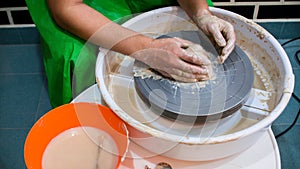 A raw clay pot in the hands of a potter. Workshop in the pottery workshop