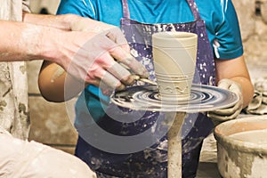 A raw clay pot in the hands of a potter. Workshop in the pottery