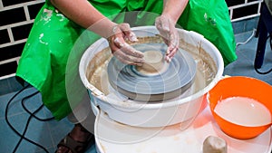 A raw clay pot in the hands of a potter. Workshop in the pottery workshop