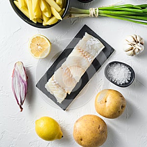 Raw cod fillet and other organic ingredients recipe fish and chips batter, potatoe, tartar sauce, lemon, capers , green herbs
