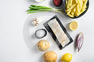 Raw cod fillet and other organic ingredients recipe fish and chips batter, potatoe, tartar sauce, lemon, capers , green herbs