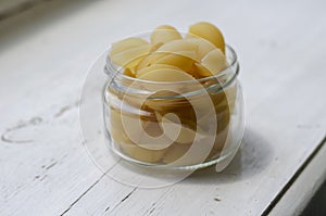 Raw Conchiglie Pasta in glass jar on white wooden background
