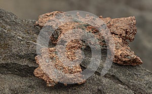 raw copper ore resting on a rock