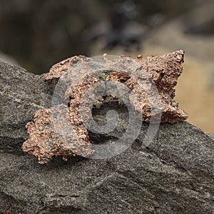 raw copper ore resting on a rock