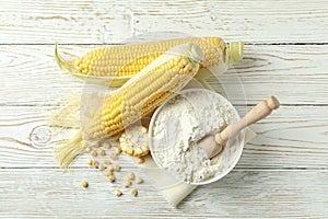 Raw corn and flour on white wooden