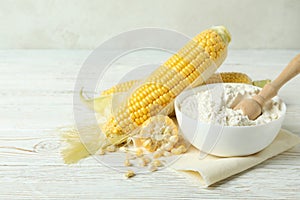 Raw corn and flour on white wooden table