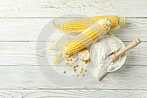 Raw corn and flour on white wooden table