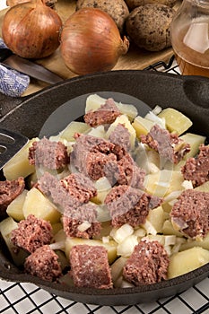 Raw corned beef hash in a cast iron pan