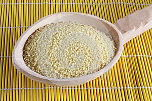Raw couscous -  cuscus on wooden spoon