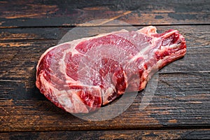 Raw cowboy or rib eye steak on the bone. Marble beef meat ribeye. Dark wooden background. Top view