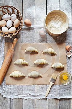 Raw croissants on parchment preparation process