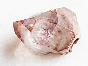 raw crystal of amethyst gemstone on white marble