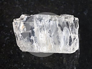 raw crystal of Petalite gemstone on dark photo
