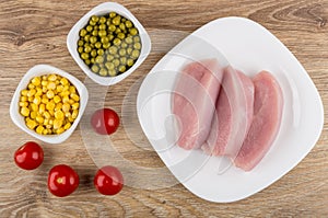Raw cutlets from turkey, tomato, sweet corn and green peas