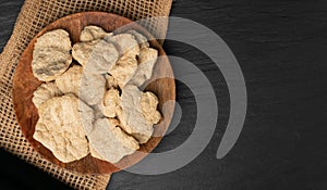 Raw Dehydrated Soy Meat or Soya Chunks on Black Stone Background