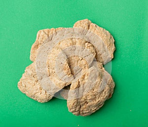Raw Dehydrated Soy Meat or Soya Chunks on Green Background