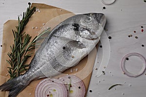 Raw dorado fish, spices and onion on white wooden table, flat lay