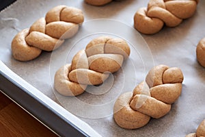 Raw dough braided bread rolls made from whole grain spelt flour, before baking