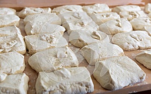 Raw dough divided into portioned pieces on baker worktable