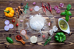 Raw dough with ingredients for homemade pizza .