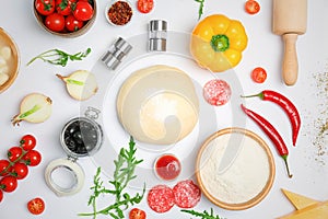 Raw dough and ingredients for pizza on white background, top view