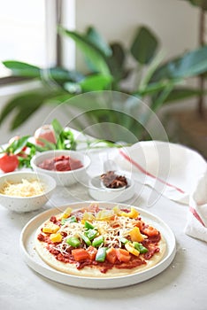 Raw dough for pizza preparation with ingredient: tomato sauce, mozzarella