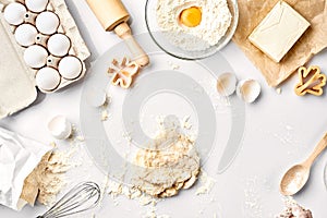 Raw dough ready for kneading on white table. Bakery ingredients, eggs, flour, butter. Shapes for making cookies.