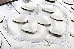 Raw dough in the shape of a heart pierogi, ravioli, dumplings