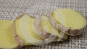 Raw Dried Ginger Root Sliced. Uncooked Spicy oriental seasoning on a kitchen mat