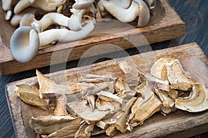 Raw and dried mushrooms in craft wooden plates