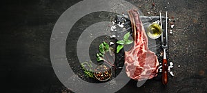 Raw dry steak tomahawk on a black background. Steak Cowboy. Barbecue. Top view.