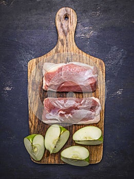 Raw duck breast with cinnamon, cloves sliced apples on a cutting board