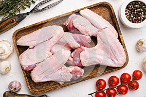 Raw duck wings, on white stone table background, top view flat lay