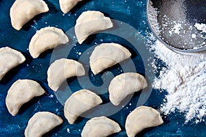Raw dumpling with potatoes. Preparation dumplings on a blue background