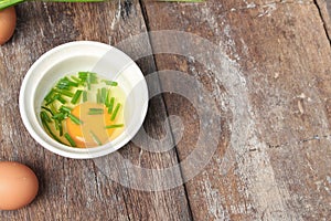 Raw egg in a bowl selective focus and onion on wooden table, Top