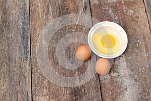 Raw egg in a bowl selective focus on wooden table