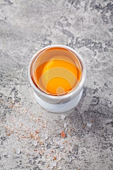 Raw egg in a eggcup on kitchen table